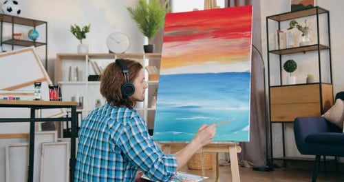 Young Adult Painting a Seascape at Home