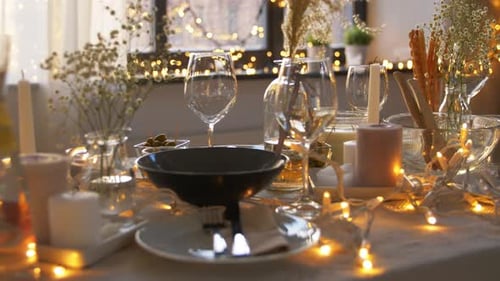 Festive table setting with candles and twinkling lights