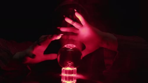 Woman with Crystal Ball in Dark Room