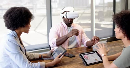 Diverse business colleagues using VR headset in modern office setting