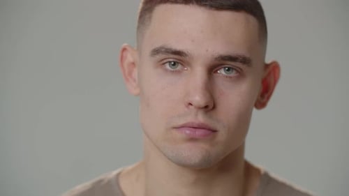 The Young Man Raises His Eyes and Looks Into the Camera Closeup of a Young Man with a Close Look