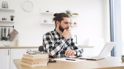 Man Works on Laptop in Bright Kitchen