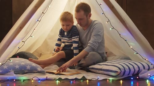 Father and Son Reading in a Cozy Tent