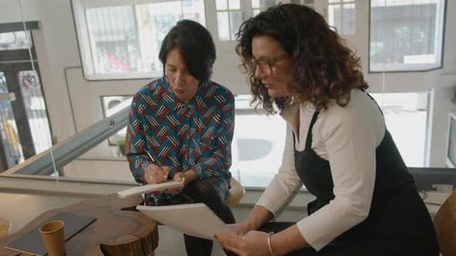 Collègues matures prenant des notes et discutant dans une salle de coworking
