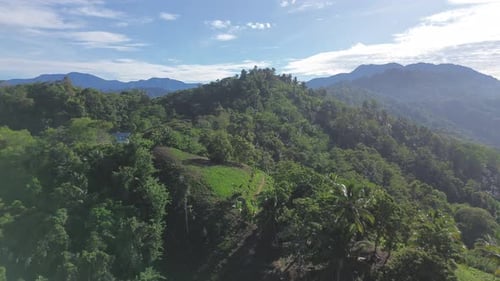 Aerial View of a Beautiful Sunrise Illuminating Green Mountain Peaks, Valleys, and Cloudy Landscape