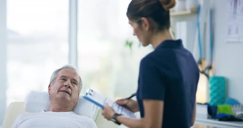 4k video footage of an attractive young female physiotherapist working with a senior male patient
