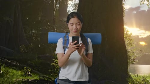 Young Woman Using Phone in a Lush Forest