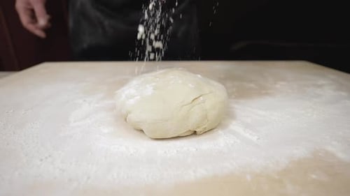 Flour Being Dusted on Ball of Dough Close Up