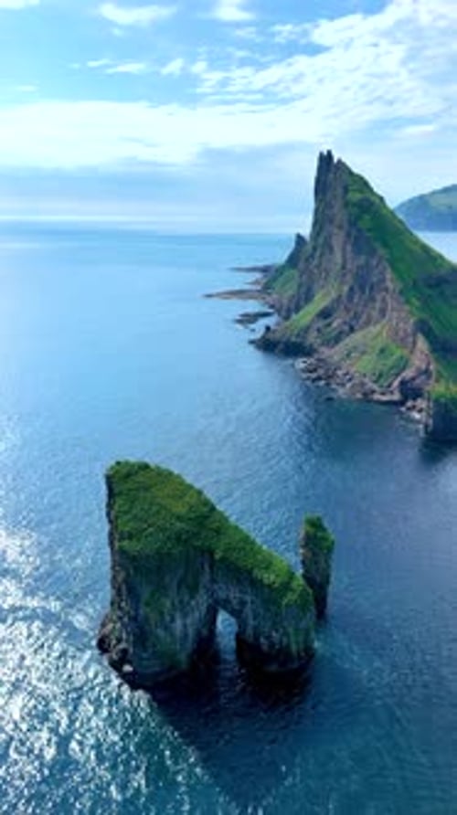 Breathtaking Coastal Cliffs and Unique Rock Formations in the Faroe Islands Under Clear Blue Skies