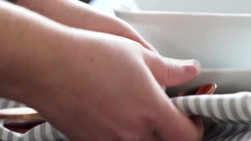 Setting Dining Table with Fork and Spoon on Napkin Close Up in Restaurant with Empty White Plates an