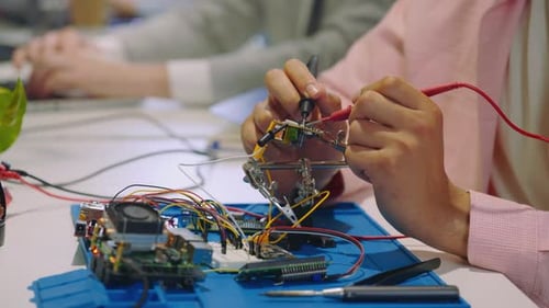 Mann misst mit Multimeter die Spannung des Motherboards im Büroraum