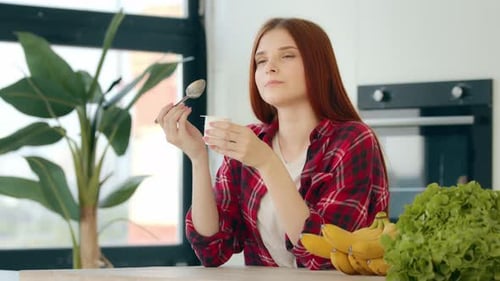 Vegetarian Caucasian Woman Redhead Female Vegan Girl Sit in Kitchen Eat Dairy Creamy Desert on
