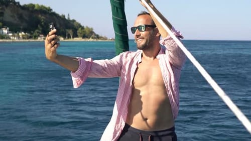 Young Man Taking Selfie Photos with Cellphone While Sailing Boat on Sea Adult