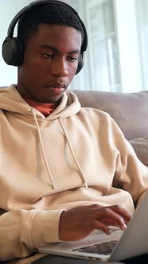 Young Adult Typing on Laptop at Home