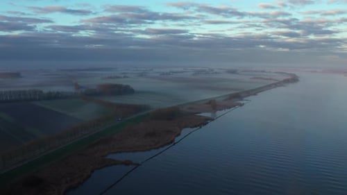 Dutch agricultural fields on the riverside, covered in the morning haze.