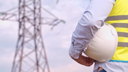 Construction worker near a Power Line Tower