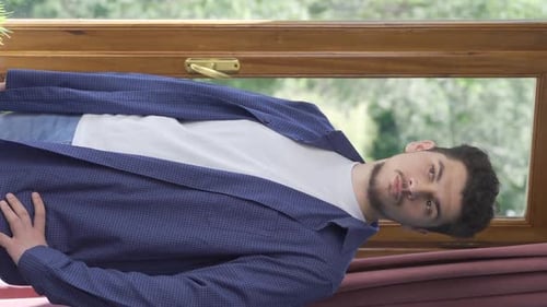 Vertikales Video von Der Mann, der die Vorhänge des Hauses schließt.