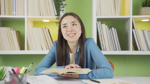 Woman Studying at Desk with Bookshelf Background