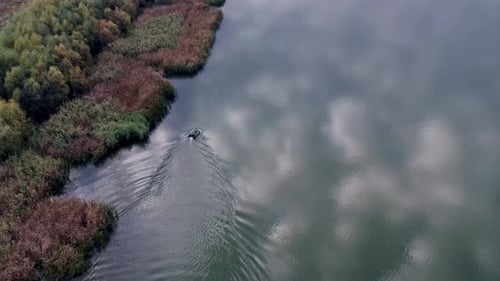 Fisherman is Fishing Sitting on an Inflatable Boat in the Middle of the River