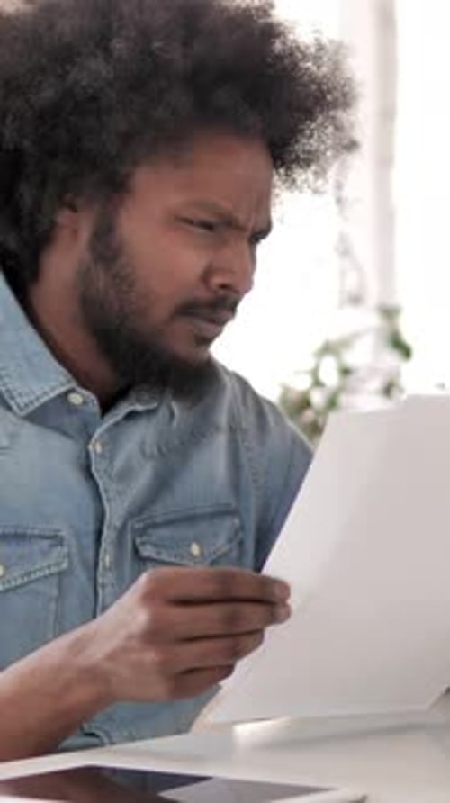 Focused Man Reviewing Important Documents Indoors