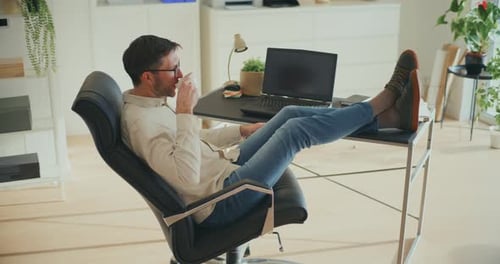 Man Relaxing with Coffee in Home Office