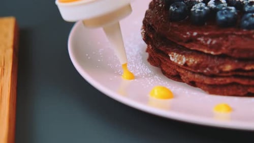 Chocolate Pancakes Drizzled with Orange Syrup Close-Up