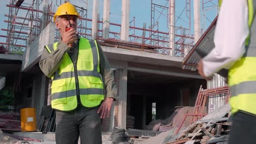 Junger Ingenieur befragt und verwendet Funkbefehle, während eine Arbeiterin oder Architektin eine Tablette aussieht.