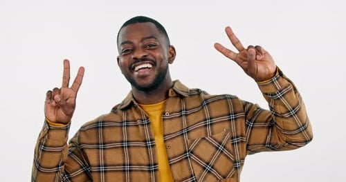 Peace, face and man in studio with smile for winning, vote and good feedback on white background