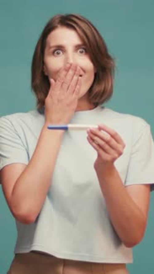 Hispanic Latin Woman Celebrates Positive Pregnancy Test Result on Sofa