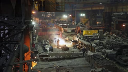An Industrial Foundry Scene Captures the Pouring of Molten Metal in an Energetic Atmosphere Stock