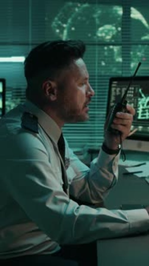 Man Communicating with Walkie Talkie in Dark Office