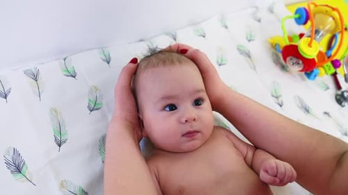 Infant Receiving a Gentle Head Massage Indoors