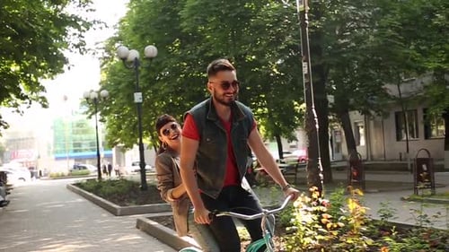 Jovem casal andando de bicicleta juntos no parque Namorado romântico andando de bicicleta com namorada feliz