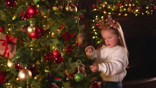 Merry Christmas Xmas Holiday Little Girl Decorating Christmas Tree on Christmas Eve at Home Young