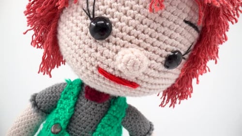 Handgemachtes gestricktes Puppenmakro auf weißem Hintergrund isoliert 4K