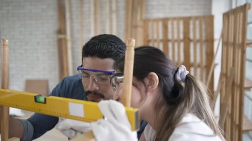 Carpenters are working at woodshop.
