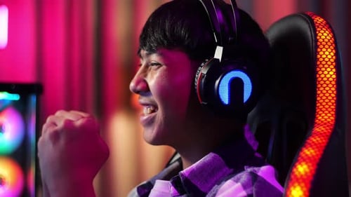 Close Up Of Excited Asian Teen Boy Gamer Celebrates Victory While Playing Video Game On Computer