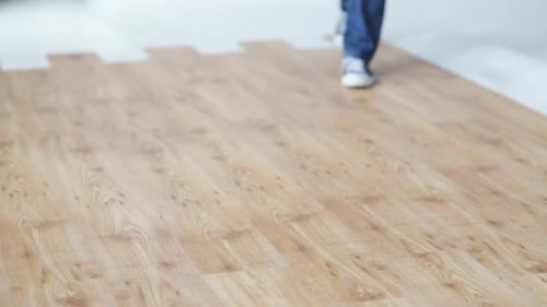 Worker Carrying Toolbox and Hardhat on Wood Floor