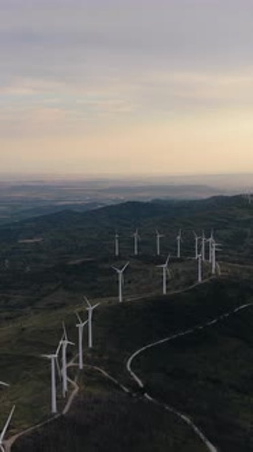 Aerial View of Wind Turbines Generating Renewable Energy on a Mountain Vertical