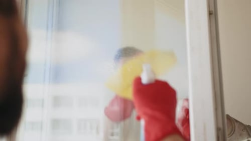 Ein Team von Arbeitern reinigt die weißen Fenster eines Büros oder einer Wohnung in Rot