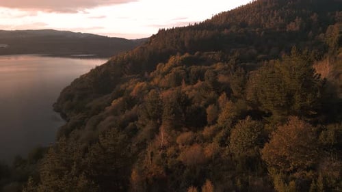 Dense Forest Mountain At Sunset In Lago das Encrobas, A Coruna, Spain. Aerial Drone Shot