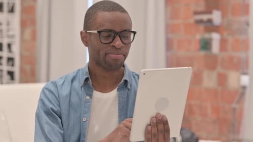 Young Adult Man Using Tablet Device Indoors