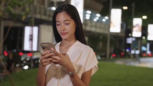Joven empresaria sonriendo con un teléfono inteligente en Bangkok Bangkok Night Lifestyle