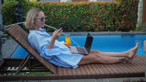 Young Woman Using Laptop Near the Swimming Pool