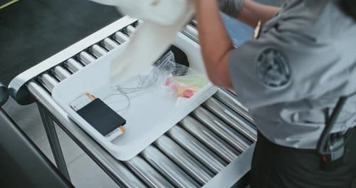 Airport Security Worker Scans Luggage and Belongings