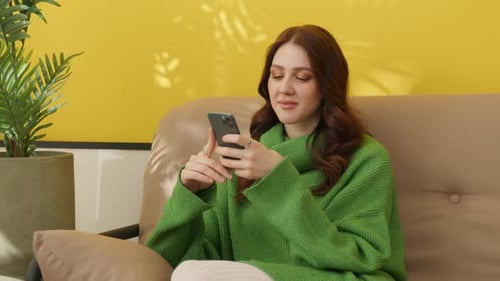 Young Woman Using Phone Casually on Sofa