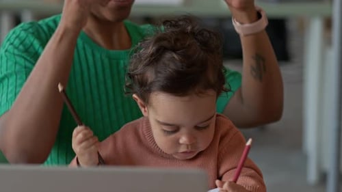 Mother and Child at Desk with Laptop and Headphones