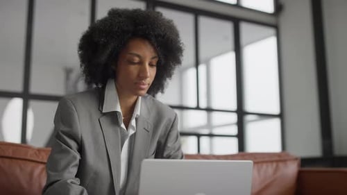 Focused Businesswoman Working on Laptop in Stylish Office Setting