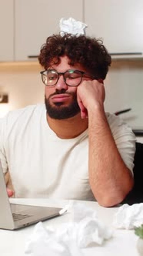 Man at Computer Frustrated with Crumpled Paper on Head