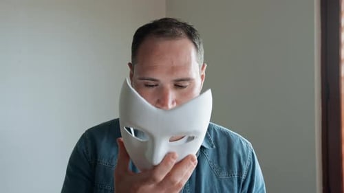Ein verrückter gruseliger Mann, der eine Maske aufsetzt